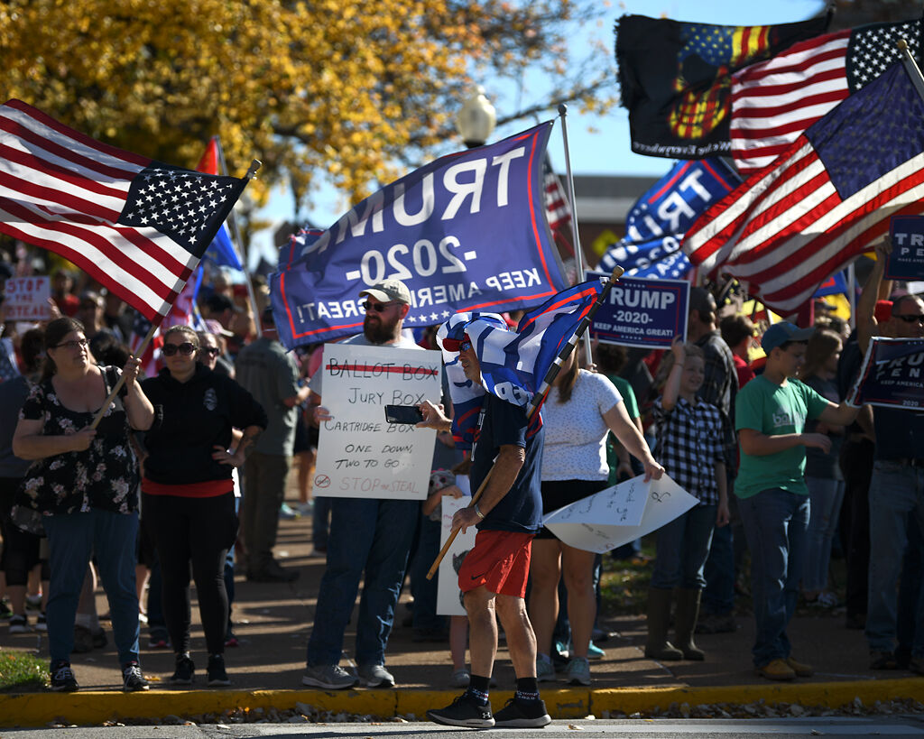 Rally attendees show off signs and flags